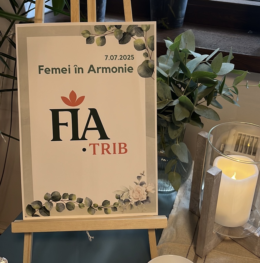 Detaliu de la evenimentul Femei în Armonie — afișul FIA TRIB înconjurat de eucalipt și lumânări